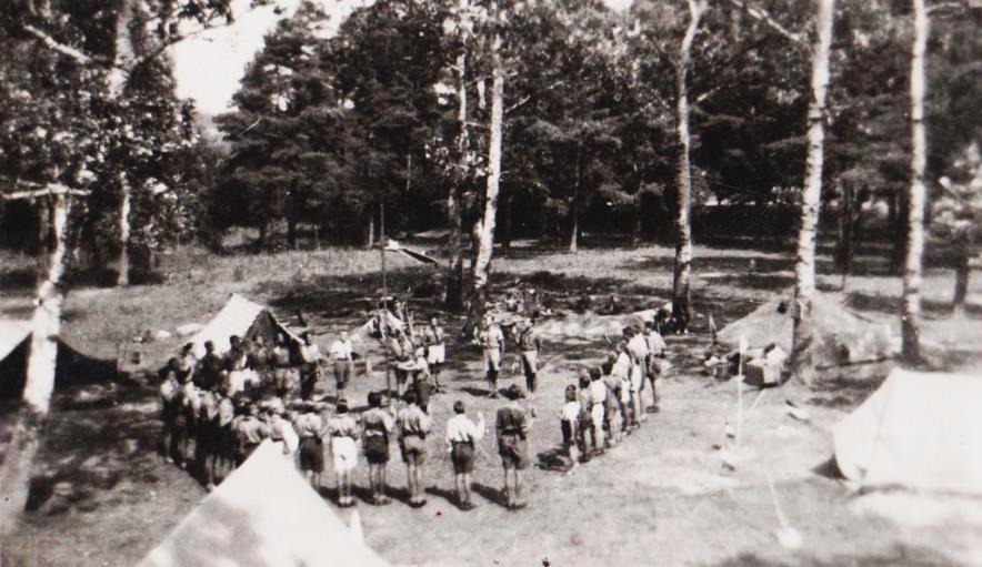 4 Cserkésztábor A fénykép készítésének helye: Fonyód-Bélatelep A fénykép készítésének ideje: 1947 Ez a kép a háború utáni második cserkésztáborban készült, a reggeli zászlófelvonás alkalmával.
