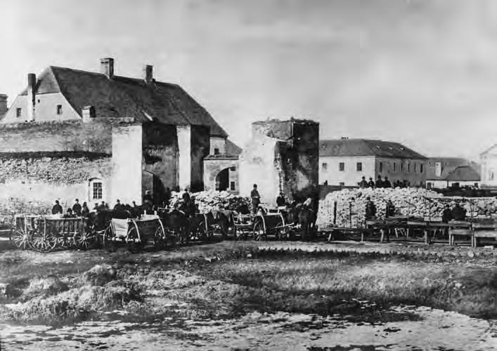 2. ábra: A déli kaputorony DK-rôl bontás közben (1881. Fotó: Lauscher Lipót) két hengeres toronyból állt. Teljes magassága 14 m, az alsó részé 9 m körüli lehetett.