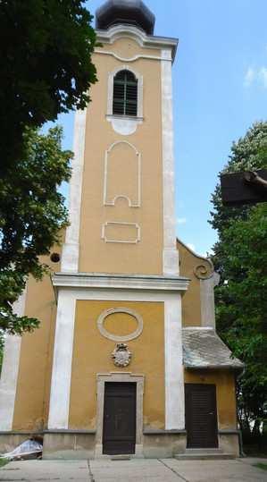 A kőkeretes nyugati kapu felett az építtető Fleischmann család címere, felette kör alakú vakablak.