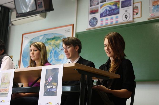 Zusammen mit zwei Regionalfinalisten aus dem Budapester Lajos Kossuth Gymnasium diskutieren sie vor Publikum und Jury über Themen und Probleme der aktuellen deutschen Jugendliteratur.