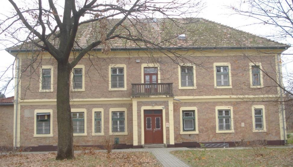 A hosszúkás, szimmetrikus homlokzatú épületet téglával burkolták.