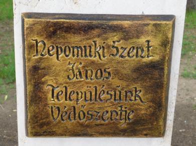 Nepomuki Szent János, a település védőszentjének szobra egy magas, hasáb alakú kő
