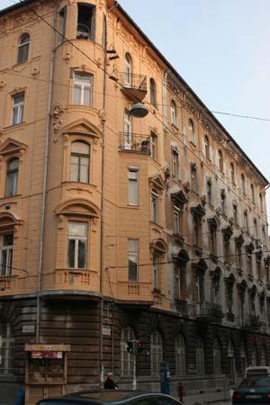 Főtengelyét ablakkal rendelkező díszesen kialakított oromzat hangsúlyozza. Zártsorú, magastetős, belsőudvaros, bérpalota.