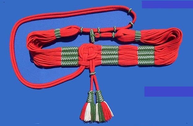 A kettőshurkok közül az egyik 5,26 cm-re elállt az öv végétől és volt rajta egy pecek, a másik 93,24 cm hosszú, fekete gombokkal hurkokra volt osztva.