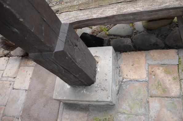 A tornác tölgyoszlopait beton lábazat veszi körül. Az oszlopok alja folyamatosan ázik, korhadt a betonlábazat által határolt részen.