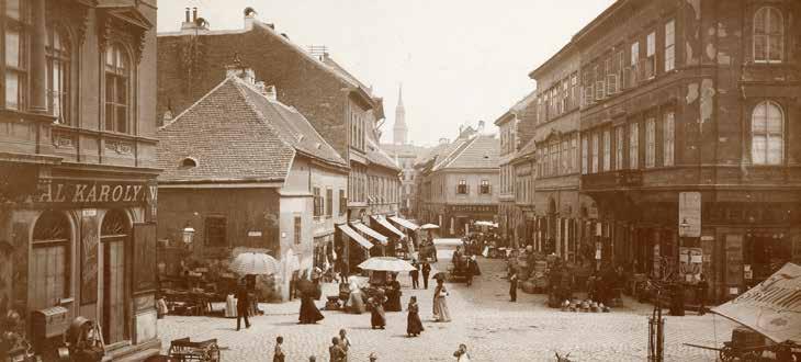 A plébánia épületének szomszédságában álló ház (amelynek az a sok rácsos ablaka van) mellett húzódott jobbra az egykori a Torony utca, ami egyenesen a Hal térbe torkollott.