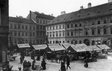 A teret ma szinte teljesen pontosan betölti a Belgrád rakpart elején álló, hatalmas bérház. A képen a Franz Fanda feliratú árnyékoló mögötti házsor az Irányi utcában állt.