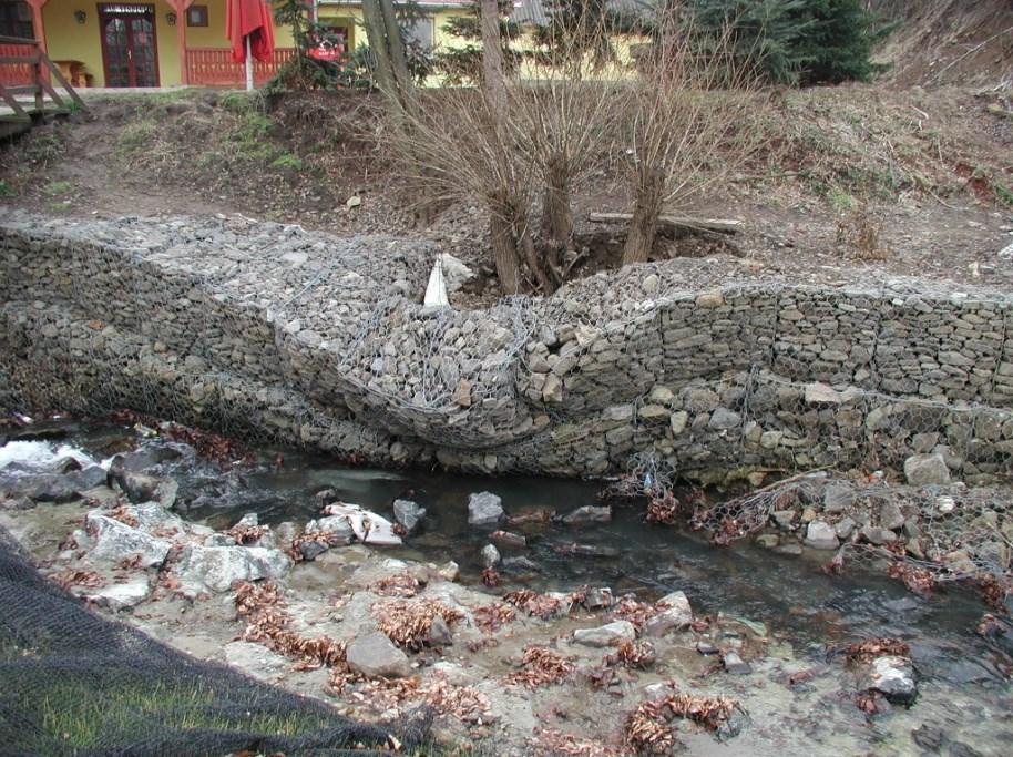 Vízfolyás rendezés 3. ábra. A mederszakasz kiborult védműve A bal parti ideiglenes vízfolyás eróziós völgyének bekötésénél a csatlakozó gabion elemek felső végénél nincs bekötő elem.