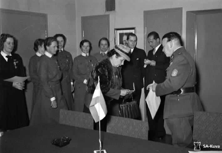 13. kép Dálnoki Veress Julianna a finn Polgárőrség Érdemkeresztjét veszi át Lauri Malmberg altábornagytól, a Polgárőrség főparancsnokától 1942 szeptemberében, Helsinkiben (SA-Kuva) által vezetett