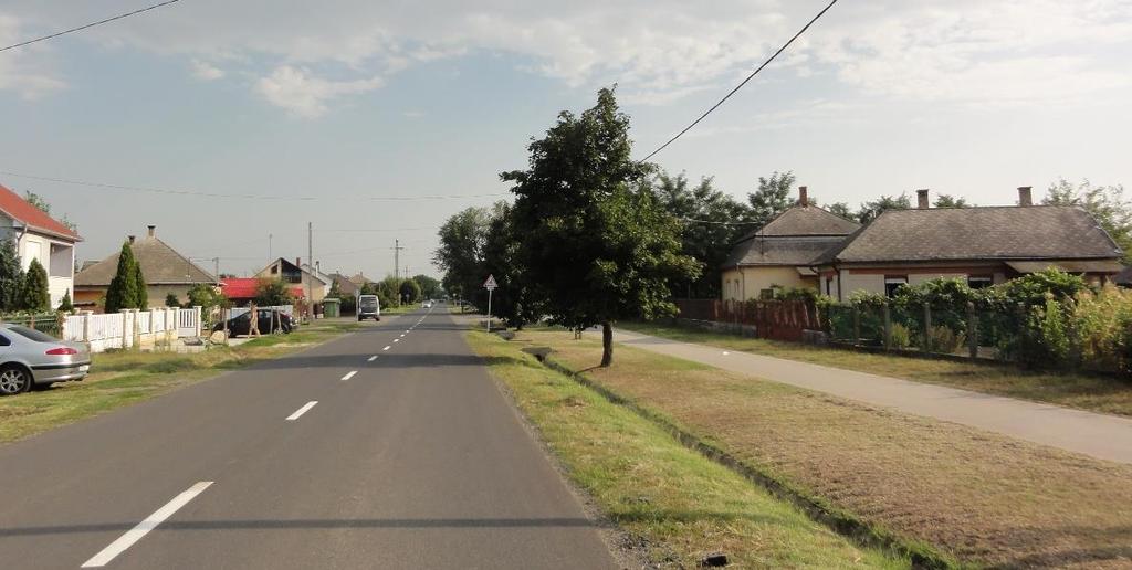a térkővel kirakott, virággal és zöld sövénnyel határolt