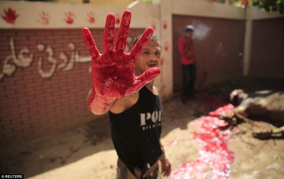Ünneplés: egy mészáros megmutatja véres kezét, miután részt vett a rituáléban, ami a szent nap ünnepségsorozatának központi eseménye.