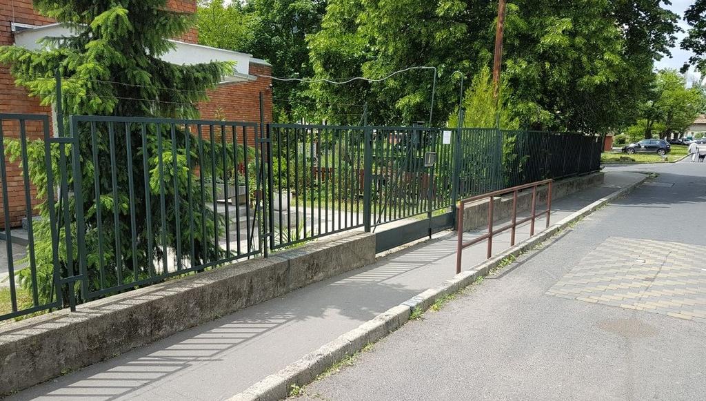 Budapest-Fót kerékpárút XV. kerületen belüli szakasza Kerékpárforgalmi Hálózati Terv kerékpártámasz, amelynek megközelítését a szűk járda és kapu, illetve a szemben található korlát nehezíti. 99.