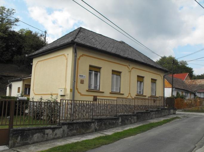 házzal találkozunk. A lábazatuk műkő vagy kővel kirakott lábazat.