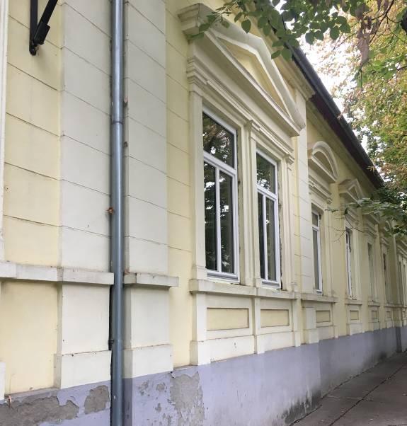 Az ablakok felett padlásszellőző nyílások láthatók. H-21 (H-13) Hősök útja 38-40. Szakközépiskola központi épülete hrsz.