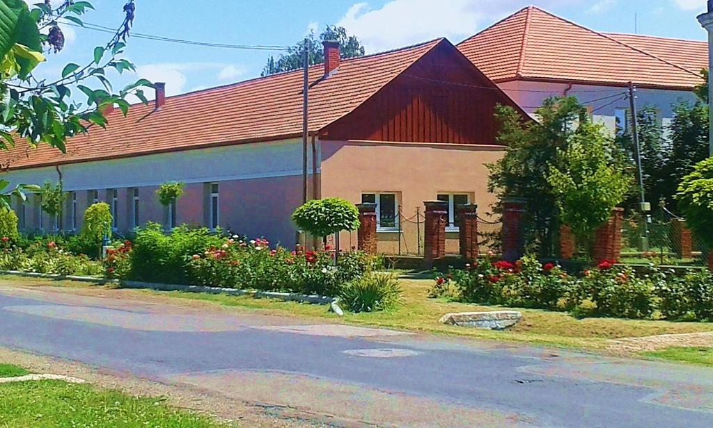 Az általános iskola utcafronton álló épülete Az előkert nélküli utcával párhuzamos gerincű épület felújítás után is megtartotta