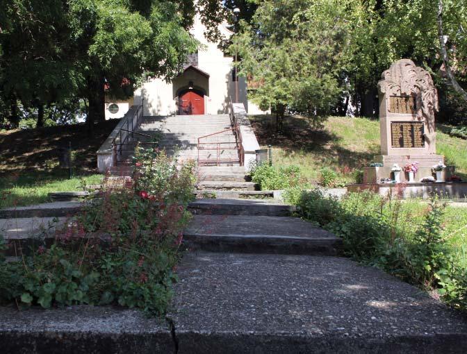 A templomkert és környezete barátságos hangulatú, bár a templom homlokzatát eltakarják a fák.