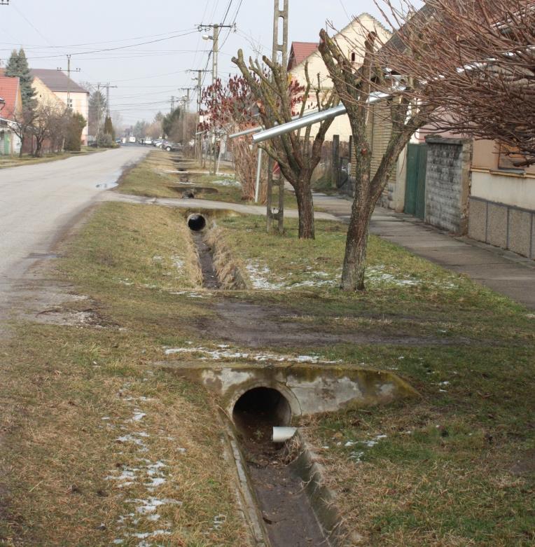 A szélesebb utcák esetében az úttest és a járda közötti zöld sávban haladnak az árkok,