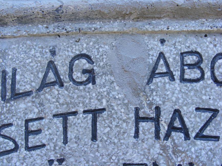 A homlok oldali szöveg első sorában a H betű mentén keletkezett repedés