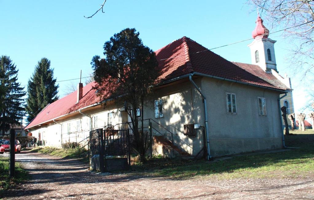 Az eredeti iskola épület a templomtól délre települt, hosszan elnyúló, a lejtő azonos