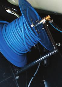 Hose reel with spray gun, working at 15-bar nozzle, for washing the machine.