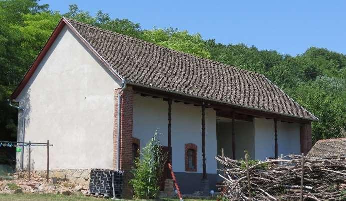 oszlopokra támaszkodó tornáccal és hagyományos nyílásrenddel kialakított épületrész.