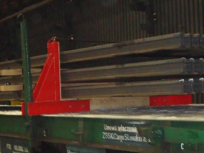 kocsipadlóra rögzített szögacél biztosítja. Más egyenértékű módszer pl.:az állványok padlóba nyomódó tüskés rögzítése is engedélyezett. két állványt mindig a rakomány végén kell elhelyezni.