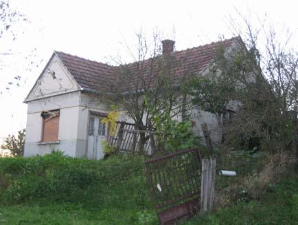 oldalhatáron álló földszintes lakóház nyeregtetővel, cserépfedéssel, T alaprajzzal.