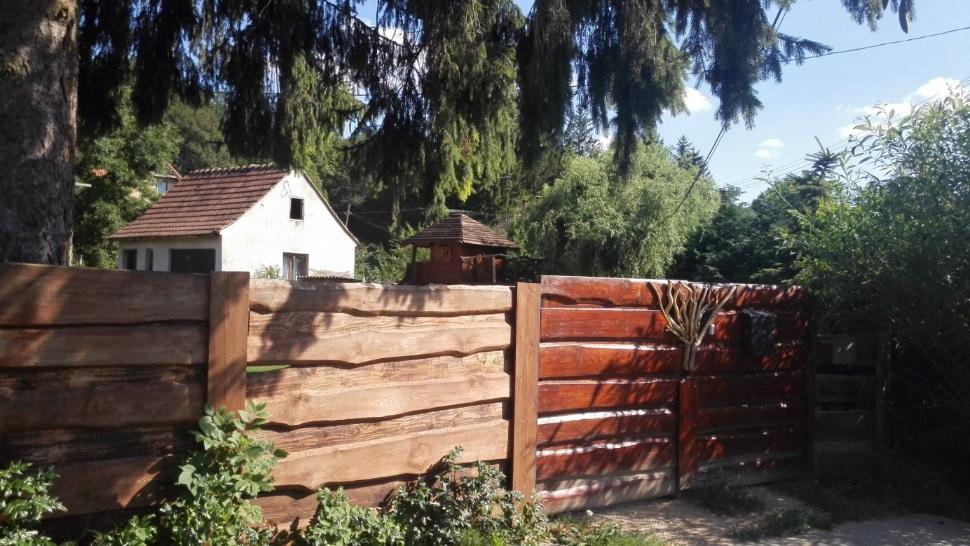 A kerítések lábazatos áttört, vagy tömör fa vagy fém kerítésmezővel, világos színnel a barnától a