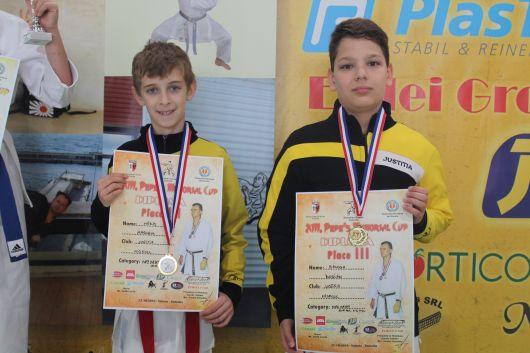 10-11 éves fiú 8-6. kyu-sok versenyében két indult. Balogh Dorián nnanko-val kezdett Hurgol Dragos (Shotokan ében. 5-0-ra győzött, ahogy a következő fordulóban is Ladányi vel (Shotokan szemben.