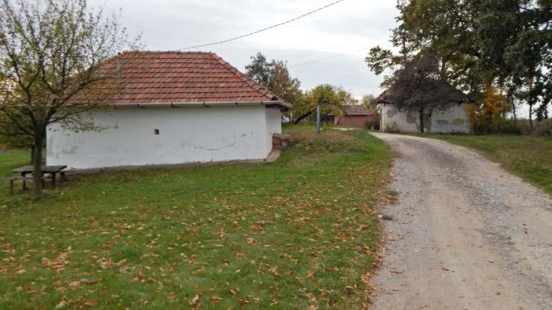 Előtte zöldfelületet, illetve felújítandó épületet találunk.