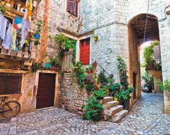 Trogir, Dalmácia egyik legszebb történelmi városa. Épületei a fallal körülvett, a 16. századi szárazföldi és tengeri kapukon keresztül megközelíthető szigeten állnak.