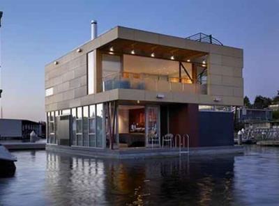 2.4.17. ábra: Úszóház Seattle-ben (USA) 2.4.18. ábra: Úszóház az Amstel folyón (Hollandia) Vízszinthez igazodó padlószintű épületek: A fix lábas és az úszóműves épülettípus keveréke.
